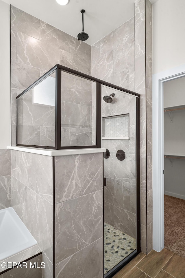 3829 Aspire Pl, El Paso, TX 79938 - bathroom featuring a shower stall, a bath, a walk in closet, and wood finished floors