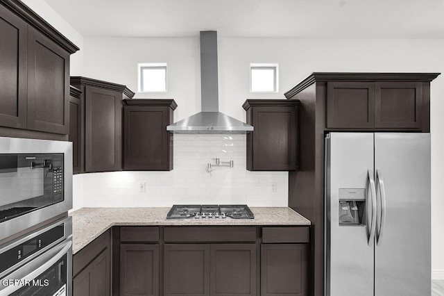 3825 Aspire Pl, El Paso, TX 79938 - kitchen with stainless steel appliances, wall chimney range hood, dark brown cabinets, and healthy amount of natural light