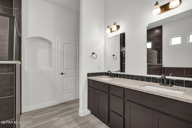 3825 Aspire Pl, El Paso, TX 79938 - full bathroom with double vanity, tiled shower, and wood finished floors