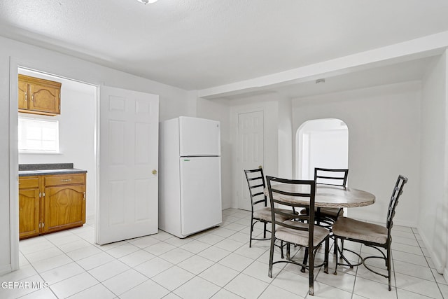 7701 Hermosillo Dr, El Paso, TX 79915 - dining space with arched walkways, light tile patterned floors, and a textured ceiling