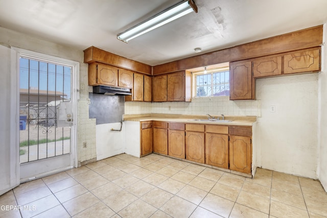 159 Silvas Way, El Paso, TX 79907 - kitchen with brown cabinets, tasteful backsplash, light countertops, and light tile patterned floors