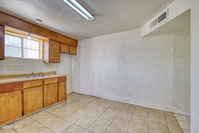 159 Silvas Way, El Paso, TX 79907 - kitchen with brown cabinetry, light countertops, backsplash, and light tile patterned floors