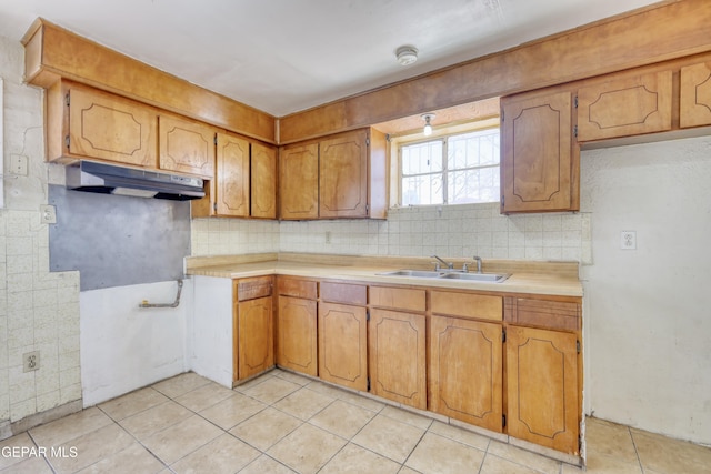 159 Silvas Way, El Paso, TX 79907 - kitchen with under cabinet range hood, tasteful backsplash, light tile patterned flooring, and brown cabinets