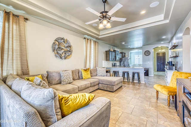 13729 Blackburn Ave, El Paso, TX 79928 - living room with arched walkways, a tray ceiling, a ceiling fan, and recessed lighting