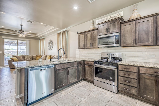 13729 Blackburn Ave, El Paso, TX 79928 - kitchen featuring appliances with stainless steel finishes, a sink, a peninsula, backsplash, and recessed lighting