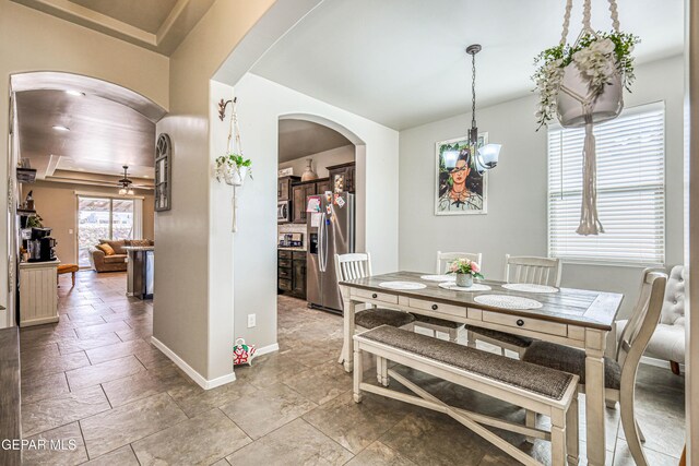 13729 Blackburn Ave, El Paso, TX 79928 - dining room with arched walkways, baseboards, a chandelier, and stone tile floors