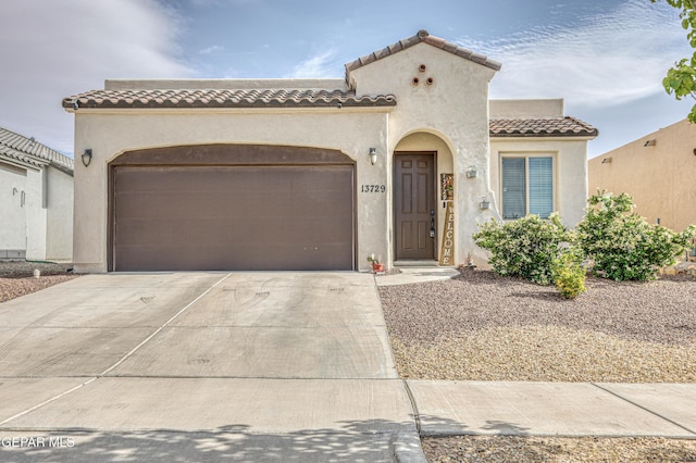 13729 Blackburn Ave, El Paso, TX 79928 - mediterranean / spanish-style house featuring a garage, a tiled roof, driveway, and stucco siding