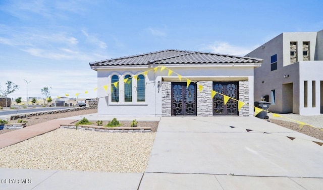 556 Cedarwood Ave, El Paso, TX 79928 - view of front facade with stone siding, stucco siding, french doors, and a tiled roof