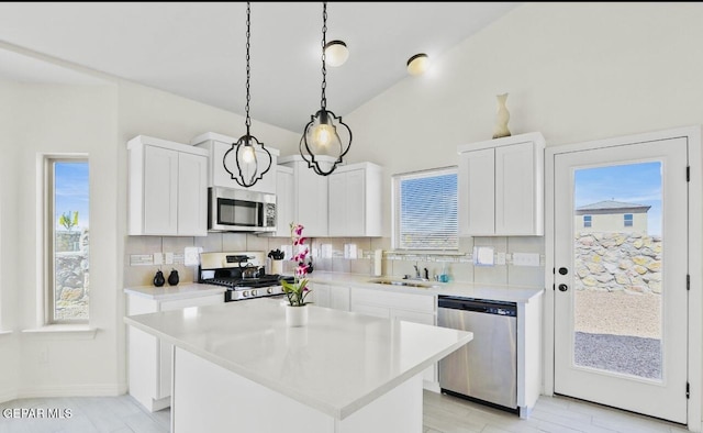 556 Cedarwood Ave, El Paso, TX 79928 - kitchen with stainless steel appliances, tasteful backsplash, light countertops, plenty of natural light, and lofted ceiling