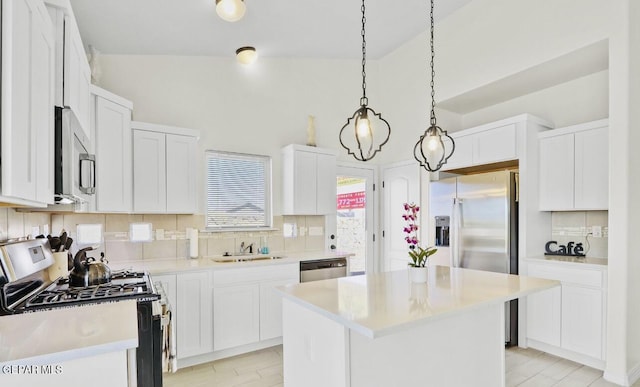 556 Cedarwood Ave, El Paso, TX 79928 - kitchen featuring appliances with stainless steel finishes, a sink, backsplash, a center island, and light countertops