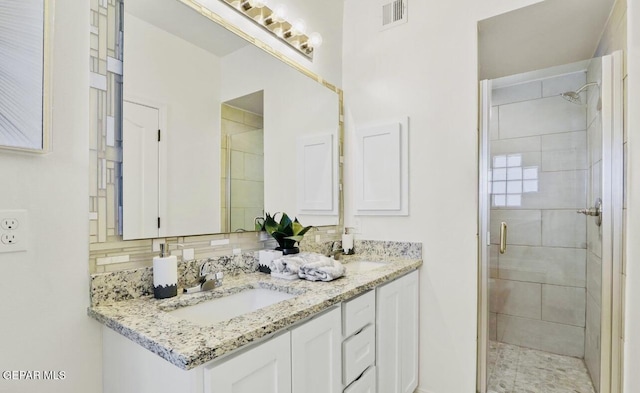 556 Cedarwood Ave, El Paso, TX 79928 - full bathroom with a shower stall, double vanity, and backsplash