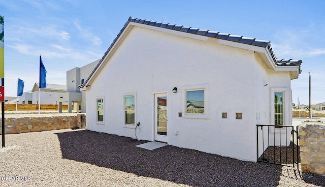 556 Cedarwood Ave, El Paso, TX 79928 - back of property featuring stucco siding, fence, and a tiled roof