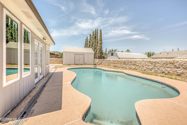 1957 Ratner Cir, El Paso, TX 79936 - view of pool with a storage shed, an outdoor structure, fence, and french doors