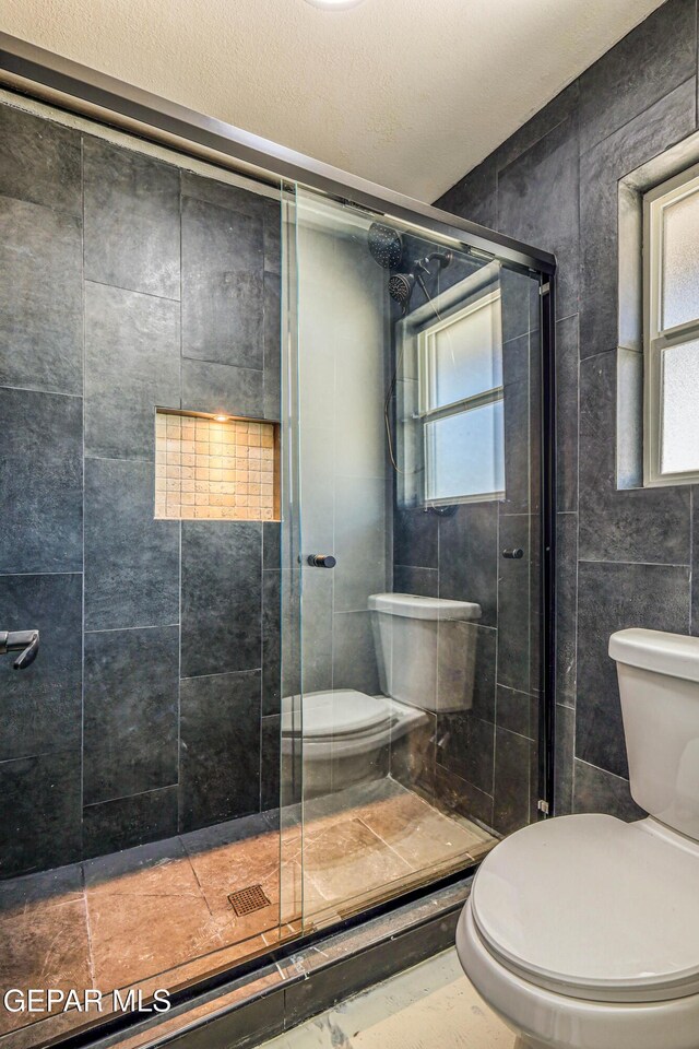1957 Ratner Cir, El Paso, TX 79936 - full bathroom featuring toilet, plenty of natural light, tile walls, and a shower stall