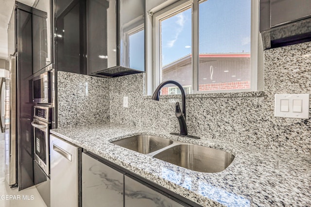 1957 Ratner Cir, El Paso, TX 79936 - kitchen with a sink, decorative backsplash, stainless steel oven, and light stone counters