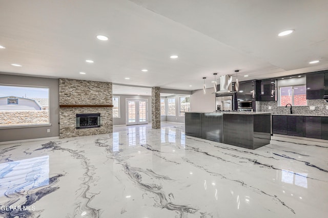 1957 Ratner Cir, El Paso, TX 79936 - kitchen with recessed lighting, decorative backsplash, open floor plan, exhaust hood, and a fireplace