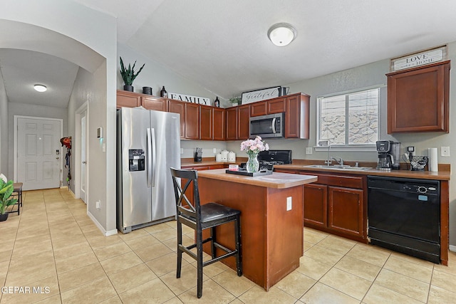 513 Bogota Pl, El Paso, TX 79928 - kitchen featuring stainless steel appliances, light tile patterned floors, a kitchen island, light countertops, and lofted ceiling