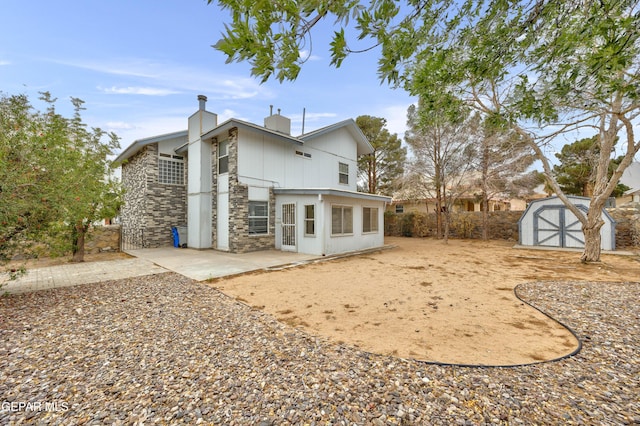 back of property featuring a storage shed, stone siding, a chimney, an outbuilding, and a patio area