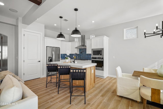 3817 Aspire Pl, El Paso, TX 79938 - kitchen with appliances with stainless steel finishes, wall chimney range hood, open floor plan, decorative backsplash, and light countertops