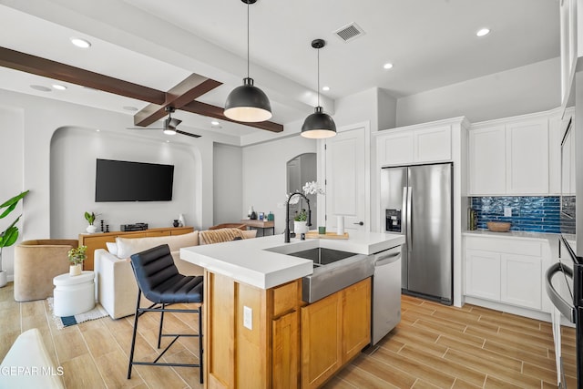 3817 Aspire Pl, El Paso, TX 79938 - kitchen featuring stainless steel appliances, a sink, arched walkways, light countertops, and an island with sink