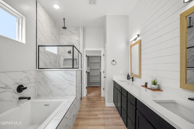 3817 Aspire Pl, El Paso, TX 79938 - full bathroom featuring a marble finish shower, a garden tub, double vanity, a spacious closet, and wood finished floors