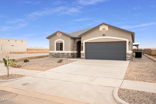 2240 Tierra Delmonte Dr, El Paso, TX 79938 - view of front of home featuring stone siding, stucco siding, driveway, an attached garage, and central AC unit