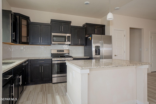 2240 Tierra Delmonte Dr, El Paso, TX 79938 - kitchen with stainless steel appliances, backsplash, a center island, and light stone counters