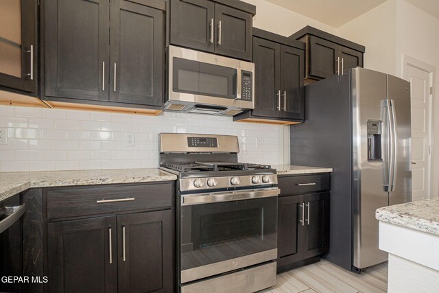 2240 Tierra Delmonte Dr, El Paso, TX 79938 - kitchen with appliances with stainless steel finishes, decorative backsplash, and light stone counters