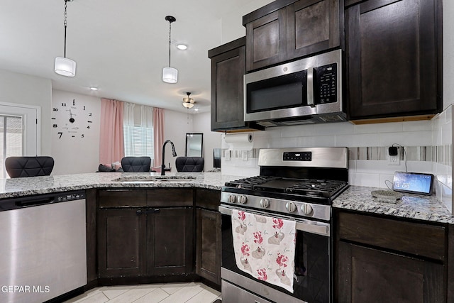 3516 Essence St, El Paso, TX 79938 - kitchen with appliances with stainless steel finishes, a sink, dark brown cabinetry, and plenty of natural light