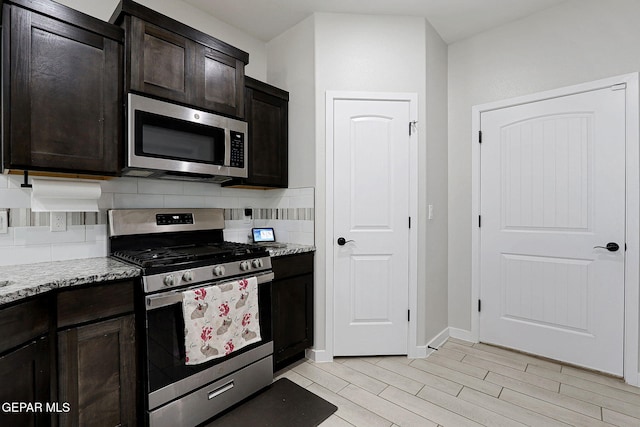 3516 Essence St, El Paso, TX 79938 - kitchen featuring stainless steel appliances, decorative backsplash, light stone countertops, light wood finished floors, and dark brown cabinetry