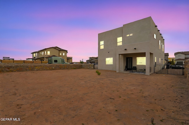 3516 Essence St, El Paso, TX 79938 - back of house at dusk with a fenced backyard, stucco siding, and a patio area