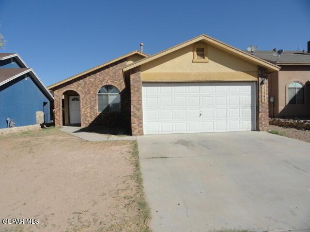 ranch-style house featuring an attached garage, driveway, stucco siding, and brick siding