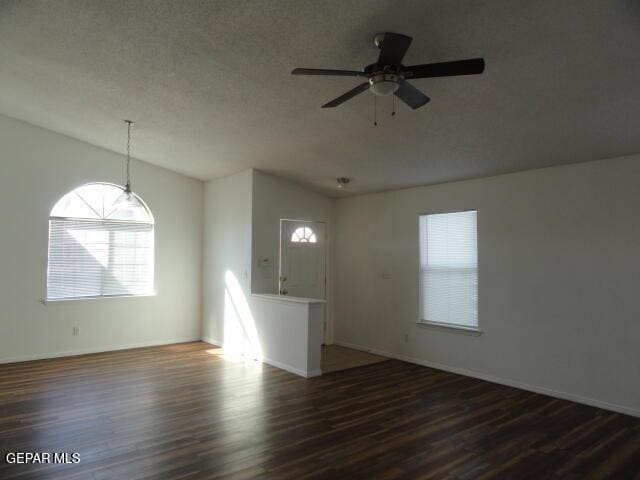 unfurnished living room featuring lofted ceiling, healthy amount of natural light, and wood finished floors