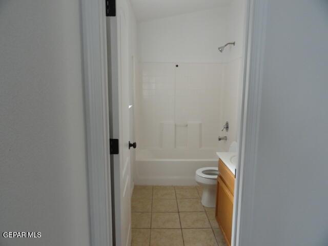full bath with tile patterned flooring, toilet, vanity, and shower / bath combination