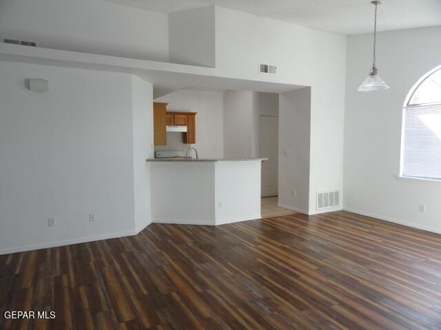 unfurnished living room featuring dark wood-style floors and baseboards