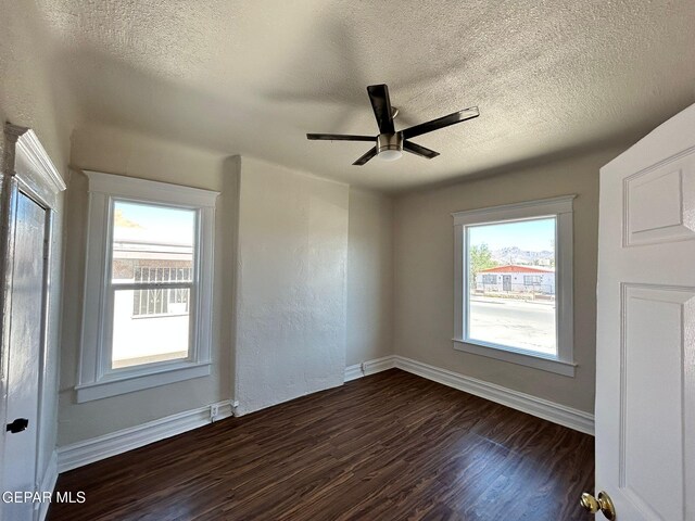 3416 Rivera Ave, El Paso, TX 79905 - unfurnished room featuring dark wood-type flooring, baseboards, a textured ceiling, and a ceiling fan