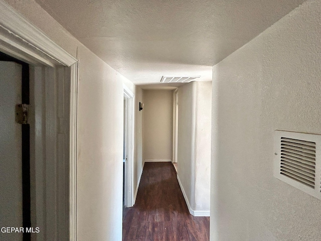 3416 Rivera Ave, El Paso, TX 79905 - hallway with dark wood-style floors, a textured wall, a textured ceiling, and baseboards
