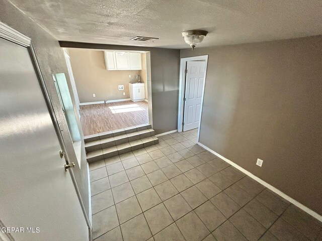 3416 Rivera Ave, El Paso, TX 79905 - unfurnished room with light tile patterned flooring, baseboards, and a textured ceiling