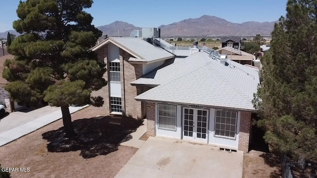 10645 Obsidian St, El Paso, TX 79924 - exterior space featuring french doors, a chimney, brick siding, and a mountain view
