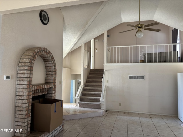 10645 Obsidian St, El Paso, TX 79924 - stairs with a ceiling fan, tile patterned floors, a brick fireplace, and high vaulted ceiling