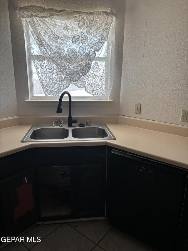 10645 Obsidian St, El Paso, TX 79924 - kitchen with black dishwasher, a sink, a textured wall, light countertops, and tile patterned floors