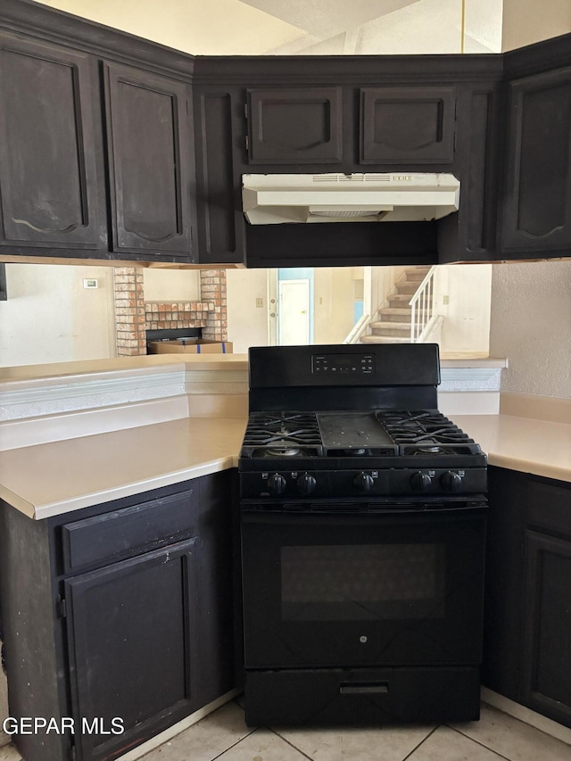 10645 Obsidian St, El Paso, TX 79924 - kitchen with black gas stove, under cabinet range hood, light countertops, and light tile patterned floors