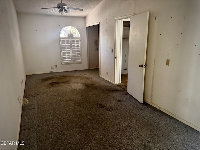 carpeted empty room featuring ceiling fan and a textured ceiling