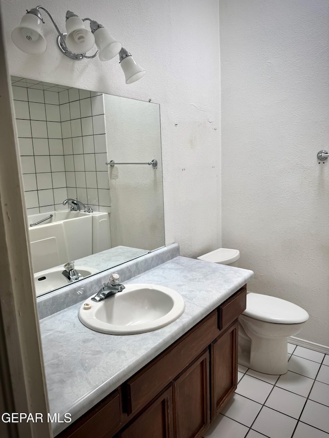 bathroom with tile patterned floors, vanity, a bath, and toilet