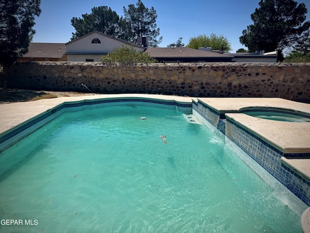 swimming pool featuring an in-ground hot tub and a fenced backyard