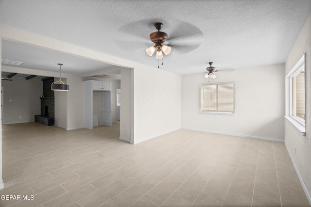 5325 Timberwolf Dr, El Paso, TX 79903 - unfurnished living room featuring a ceiling fan, healthy amount of natural light, a textured ceiling, and baseboards