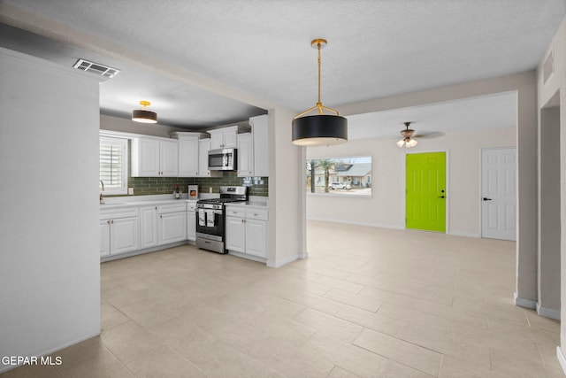 5325 Timberwolf Dr, El Paso, TX 79903 - kitchen featuring stainless steel appliances, a ceiling fan, decorative backsplash, light countertops, and white cabinets