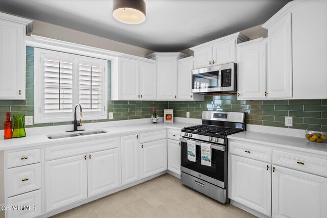 5325 Timberwolf Dr, El Paso, TX 79903 - kitchen featuring stainless steel appliances, a sink, white cabinets, and light countertops
