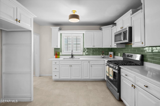 5325 Timberwolf Dr, El Paso, TX 79903 - kitchen featuring appliances with stainless steel finishes, a sink, light countertops, decorative backsplash, and white cabinetry
