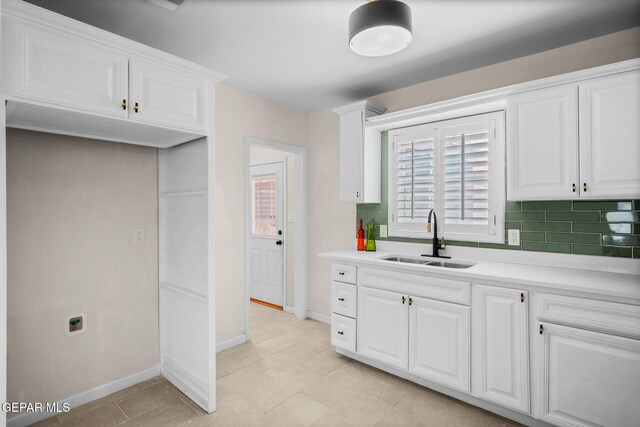 5325 Timberwolf Dr, El Paso, TX 79903 - kitchen featuring a sink, decorative backsplash, white cabinetry, and baseboards